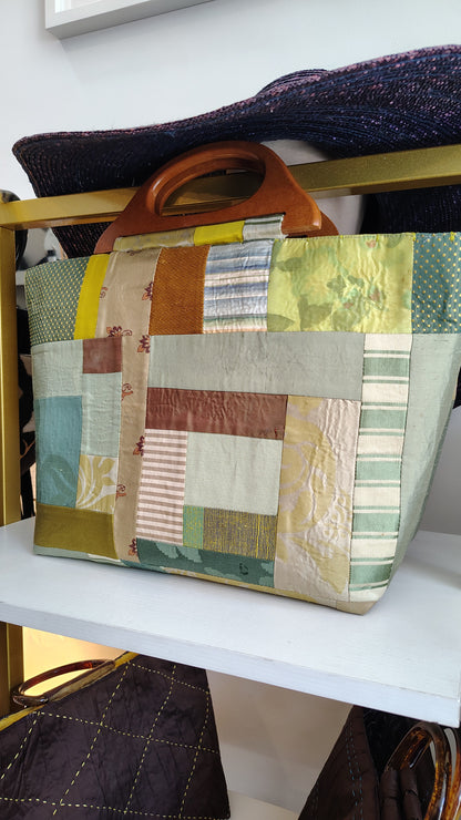 Constructed fabric green silk bag with wood handle